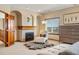 A well-lit bedroom with a fireplace, window views, an accent chair, and a fur rug at 4320 Stone Post Dr, Castle Rock, CO 80108