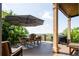Outdoor living area featuring a grill, wood flooring, an umbrella, and a lovely backyard view at 4320 Stone Post Dr, Castle Rock, CO 80108