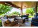 Covered outdoor patio area with comfortable seating, a stone fireplace, and overhead heat lamps at 4320 Stone Post Dr, Castle Rock, CO 80108
