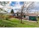 Expansive backyard featuring a deck, mature trees, and a well-maintained lawn perfect for outdoor enjoyment at 4917 S Xenophon Way, Morrison, CO 80465