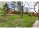 Spacious backyard with green lawn, mature trees, and a wooden fence providing privacy at 4917 S Xenophon Way, Morrison, CO 80465