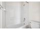Bathroom featuring tub and shower with white tile surround, and white fixtures at 12997 Wyandot Way, Westminster, CO 80234