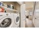 Bright laundry room includes a washer, dryer, and shelving for easy organization and storage at 3912 S Carson St # 204, Aurora, CO 80014