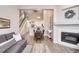 Open-concept living area featuring a fireplace, wood floors, and stairs to the second floor at 3912 S Carson St # 204, Aurora, CO 80014