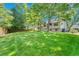 A backyard with a vast green lawn, large trees, and a house, perfect for relaxation and entertainment at 5543 S Kenton Ct, Englewood, CO 80111