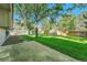 A spacious backyard with a lush green lawn surrounded by mature trees and a wooden fence at 5543 S Kenton Ct, Englewood, CO 80111