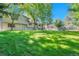 Large backyard with green lawn, mature trees, and view of house, perfect for outdoor activities at 5543 S Kenton Ct, Englewood, CO 80111