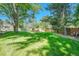 Spacious backyard with lush lawn, mature trees, and wooden fence, offering privacy and tranquility at 5543 S Kenton Ct, Englewood, CO 80111