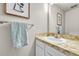 Well-lit powder room with a marble-look countertop, white cabinetry, and decorative art at 5543 S Kenton Ct, Englewood, CO 80111