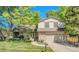 Charming home with a stone facade, well-manicured lawn, mature trees, and an attached two-car garage at 5543 S Kenton Ct, Englewood, CO 80111