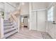 Welcoming foyer with a staircase, light colored walls and wood-look floors and a coat closet at 5543 S Kenton Ct, Englewood, CO 80111