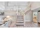 Open-concept foyer with staircase, light-toned walls and wood-look floors transitions into a living area at 5543 S Kenton Ct, Englewood, CO 80111
