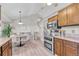 Bright kitchen featuring modern appliances, wood cabinetry, and seamless access to a dining area for everyday living at 5543 S Kenton Ct, Englewood, CO 80111