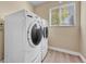 Bright laundry room with a white, front-load washer and dryer set with a window to let in natural light at 5543 S Kenton Ct, Englewood, CO 80111
