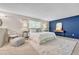 Spacious main bedroom boasts a plush white rug, blue accent wall, and comfortable seating at 5543 S Kenton Ct, Englewood, CO 80111