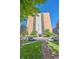 High-rise brick building with balconies, surrounded by well-maintained landscaping and street parking at 955 Eudora St # 203E, Denver, CO 80220
