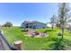 Spacious backyard featuring a fire pit, swing, and lush green grass with picturesque rural views at 11499 County Road 40 1/2 Rd, Platteville, CO 80651