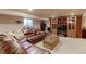 Basement living room featuring a large leather couch, a TV, and a small basement window at 11499 County Road 40 1/2 Rd, Platteville, CO 80651