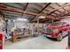Interior view of large garage with a red truck, metal shelving, and a workbench at 11499 County Road 40 1/2 Rd, Platteville, CO 80651