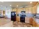 Modern kitchen featuring wood cabinets, a black refrigerator, and a breakfast bar at 11499 County Road 40 1/2 Rd, Platteville, CO 80651