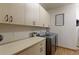 Spacious laundry room featuring a front load washer and dryer and ample cabinet storage at 11499 County Road 40 1/2 Rd, Platteville, CO 80651