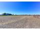 Lot with a blue ranch home in the distance, and fencing that divides the property at 11499 County Road 40 1/2 Rd, Platteville, CO 80651