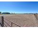 View of a large riding arena with pipe fence surrounding the area and a home in the background at 11499 County Road 40 1/2 Rd, Platteville, CO 80651