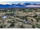 An aerial view showcases the expansive landscape with a pond and scattered trees at 10426 Tomahawk Rd, Parker, CO 80138