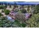 An aerial view showcases the unique home and landscape surrounded by trees in a scenic location at 10426 Tomahawk Rd, Parker, CO 80138