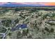 A panoramic aerial view showcases the expansive landscape and a serene pond at 10426 Tomahawk Rd, Parker, CO 80138