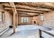 Spacious living room with beamed ceilings, wood pillars, a fireplace, and brick flooring at 10426 Tomahawk Rd, Parker, CO 80138