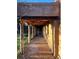 Covered walkway showing a brick path with rustic wooden pillars, beams, and desert landscaping at 10426 Tomahawk Rd, Parker, CO 80138