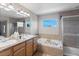 Bright bathroom features a soaking tub, glass shower, double sinks, and a large mirror at 4515 W 107Th Cir, Westminster, CO 80031