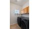 Convenient laundry room with front-load washer and dryer and upper cabinets at 4515 W 107Th Cir, Westminster, CO 80031