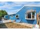 Charming blue home exterior featuring a bay window and access to the backyard space at 935 S Pecos Way, Denver, CO 80223