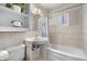 Compact bathroom with a built-in shelf, tile walls, and a shower-tub combination at 935 S Pecos Way, Denver, CO 80223