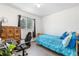 Cozy bedroom featuring a study space, window view, and a single bed with blue linens at 935 S Pecos Way, Denver, CO 80223