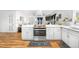 Contemporary kitchen featuring white cabinetry, stainless steel appliances, and a spacious island at 935 S Pecos Way, Denver, CO 80223