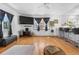 Cozy living area featuring hardwood floors, a large TV, and access to the updated kitchen at 935 S Pecos Way, Denver, CO 80223