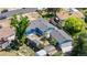 Aerial view of a blue single-story home featuring a spacious backyard, greenhouse, and detached garage at 935 S Pecos Way, Denver, CO 80223