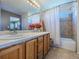 Bright bathroom with a white countertop, oak cabinets, tile flooring and shower-tub combination with tile surround at 5369 Creek Way, Parker, CO 80134