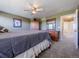 Cozy bedroom featuring carpet, a ceiling fan, a wooden dresser, and a large bed with a gray comforter at 5369 Creek Way, Parker, CO 80134