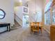 Bright dining area adjacent to the living room features a staircase, decor niche, and large arched window at 5369 Creek Way, Parker, CO 80134