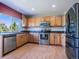Bright kitchen featuring stainless steel appliances, wood cabinets, and a large window offering scenic outdoor views at 5369 Creek Way, Parker, CO 80134