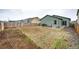 Expansive backyard with wood fence and patio offers potential for landscaping and outdoor enjoyment at 316 Maple St, Bennett, CO 80102