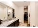 Bathroom featuring modern vanity with granite countertops and a separate walk-in closet at 316 Maple St, Bennett, CO 80102