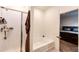 Bright bathroom includes a shower, soaking tub, and an open doorway to the main bedroom at 316 Maple St, Bennett, CO 80102