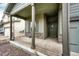 Covered front porch with stone accents and columns with view of front door at 316 Maple St, Bennett, CO 80102