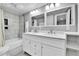 Bathroom featuring a dual sink vanity, modern lighting, and a tiled shower/tub at 3331 S Monaco Pkwy # C, Denver, CO 80222
