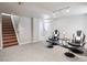 Carpeted basement area with staircase, featuring comfortable seating near a window at 9816 S Holland St, Littleton, CO 80127
